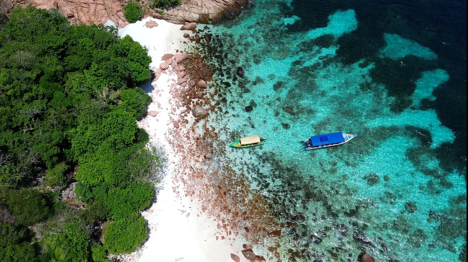 Fotografía aérea de Perhentian: costa verde, barcas y agua turquesa